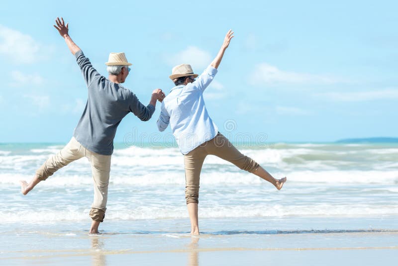 Asian Lifestyle senior couple jumping on the beach happy in love romantic and relax time.Â 
